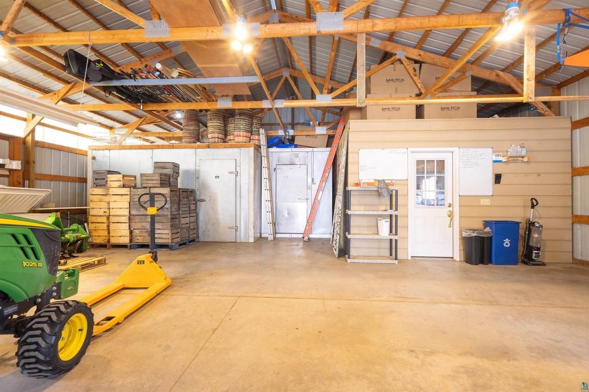 Inside the pole barn, looking toward the rear bay and its white doors.