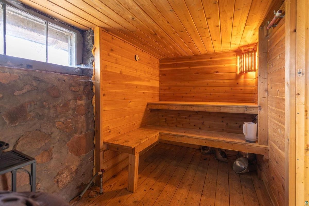 Cedar-lined sauna inside the milkhouse, with a bench and a small window.